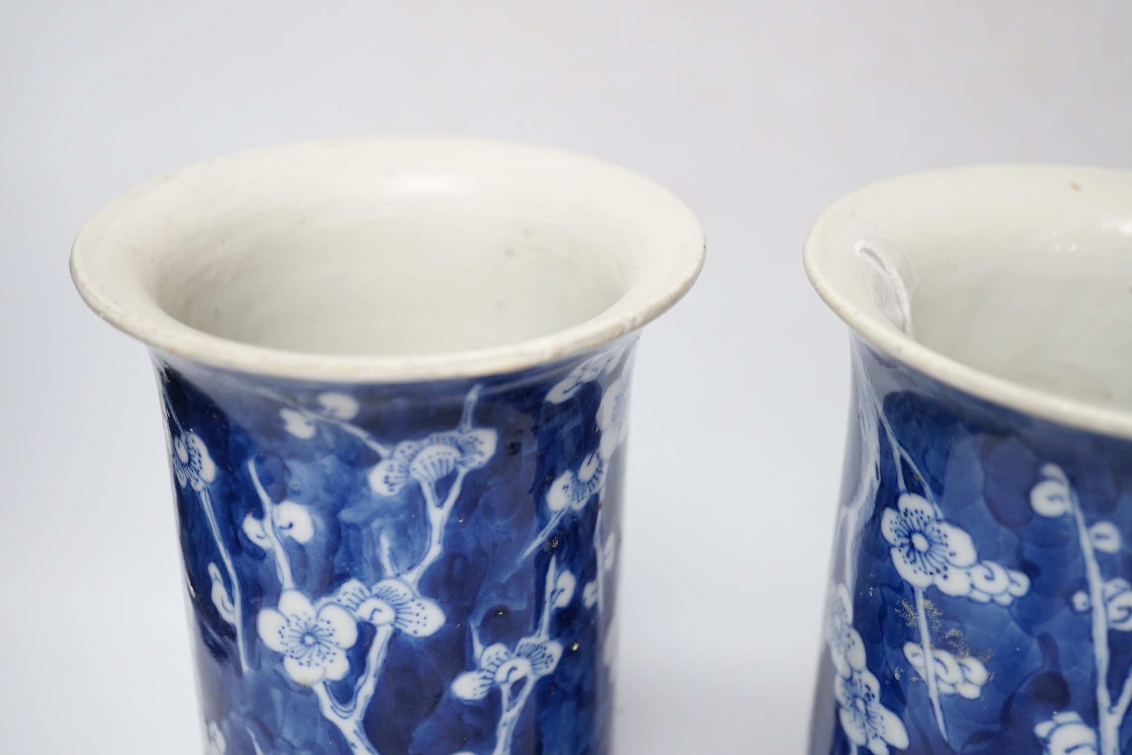 A pair of Chinese blue and white prunus flower sleeve vases, c.1900, (restored), 26cm high
